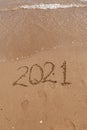 inscription on the sand 2021. symbol 2021 on the coast, overlooking the sea. Summer holidays in the new season. Royalty Free Stock Photo