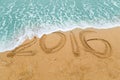 2016 inscription on sandy beach washed off with approaching wave Royalty Free Stock Photo