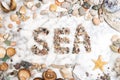 Inscription sea with pebbles, star, stones and shells lying on a marble background, composition of sea stones and seashells, word