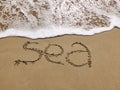 Inscription Sea on the sandy beach and foamy sea water Royalty Free Stock Photo