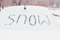 The inscription Snow on car glass, after snowfall in the winter