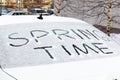 inscription on the snow-covered rear window of the car spring time on a bright sunny day. close-up