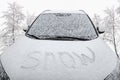 The inscription snow, on the hood of the car, covered with snow