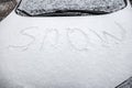 The inscription snow, on the hood of the car, covered with snow