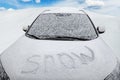 The inscription snow, on the hood of the car, covered with snow