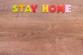 Inscription STAY HOME of wooden letters on wood background with copy space