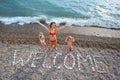 Inscription from stones WELCOME at coast, family