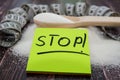 The inscription `stop` on a yellow sticker on the background of sugar and a measuring tape. Side view. Wood background. The concep