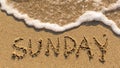 Inscription SUNDAY on a gentle beach sand with the soft wave. Royalty Free Stock Photo