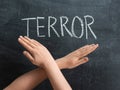 The inscription TERROR on a chalkboard, crossed female hands on the background of the text Royalty Free Stock Photo