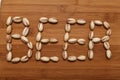 Inscription, text, beer with pistachios on a wooden table.