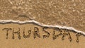 Inscription THURSDAY on a gentle beach sand with the soft wave Royalty Free Stock Photo