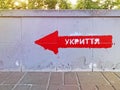The inscription in Ukrainian SHELTER on the wall. Signpost direction to the bomb shelter in Ukrainian. Bomb shelter sign on the