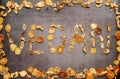 Inscription vegan from pieces of dried fruits in a fruit frame on a dark background