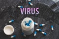 The inscription virus on the background of pills on a black table. Royalty Free Stock Photo