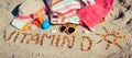 Inscription vitamin D, accessories for relax and childrens playing on sand at beach. Prevention of vitamin D deficiency. Healthy Royalty Free Stock Photo