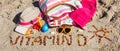 Inscription vitamin D, accessories for relax and childrens playing on sand at beach. Prevention of vitamin D deficiency Royalty Free Stock Photo