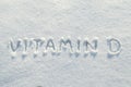 Inscription vitamin D on clean snow, in the bright rays of the winter sun. Health concept. Copy space.