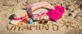 Inscription vitamin D, shape of sun and accessories for relax on sand at beach. Prevention of vitamin D deficiency and healthy Royalty Free Stock Photo