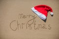 Inscription on the wet sand and cap of Santa Claus Royalty Free Stock Photo