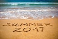 Inscription on wet sand Summer 2017. Concept photo of summer vacation on the tropical island ocean beach Royalty Free Stock Photo