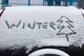 Inscription winter and tree on snow on the back window of car, SUV