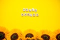 inscription from wooden blocks hello august. Bright juicy sunflowers on a bright yellow background. Layout. Royalty Free Stock Photo