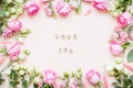 Inscription of wooden blocks love you. Frame of delicate white and pink roses and eustomas on a light pink background Royalty Free Stock Photo