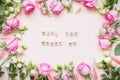 Inscription of wooden blocks will you marry me. Frame of delicate white and pink roses and eustomas on a light pink Royalty Free Stock Photo