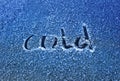 Inscription the word cold scraped on the frosty glass covered with white crystals and placed on the car window on a winter cold