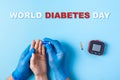 Inscription world diabetes day, Nurse making a blood test with lancet. Man`s hand with red blood drop and Glucose meter Royalty Free Stock Photo