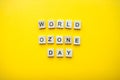 The inscription world ozone day from wooden blocks on a bright yellow background