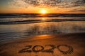2020 inscription written on sandy beach