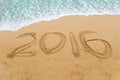 2016 inscription written on sandy beach with wave approaching Royalty Free Stock Photo