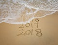 2018 and 2017 inscription written in the wet beach sand Royalty Free Stock Photo