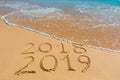 2018 2019 inscription written in the wet yellow beach sand being Royalty Free Stock Photo