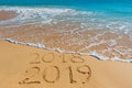 2018 2019 inscription written in the wet yellow beach sand being Royalty Free Stock Photo