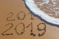 2018 2019 inscription written in the wet yellow beach sand being Royalty Free Stock Photo