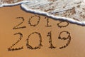 2018 2019 inscription written in the wet yellow beach sand being Royalty Free Stock Photo