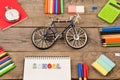 inscription of & x22;school& x22;, bicycle model, stopwatch, calculator, notepads and other stationery on brown wooden table Royalty Free Stock Photo