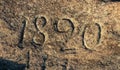 The inscription of the year 1820 embossed on the surface of a granite stone