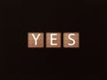 inscription YES on wooden blocks on black background. Letter text on wooden cube Royalty Free Stock Photo