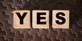 The inscription YES on wooden blocks on dark background Royalty Free Stock Photo