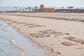 Inscriptions on the sand with sea waves