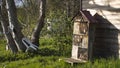 Insect hotel against a wooden house, in a beautiful vegetable garden, in early spring Royalty Free Stock Photo