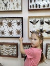 The insectarium on the wall surprised the little girl very much. Emotions.