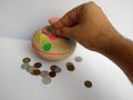 Inserting coin in a piggy bank or a gullak