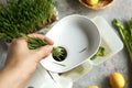 Putting fresh green barley grass blades into a juicer to prepare homemade juice Royalty Free Stock Photo