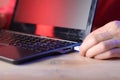 Inserting usb cable into laptop on table Royalty Free Stock Photo