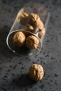 Inshell walnuts fall of glass container on concrete terrazzo countertop Royalty Free Stock Photo